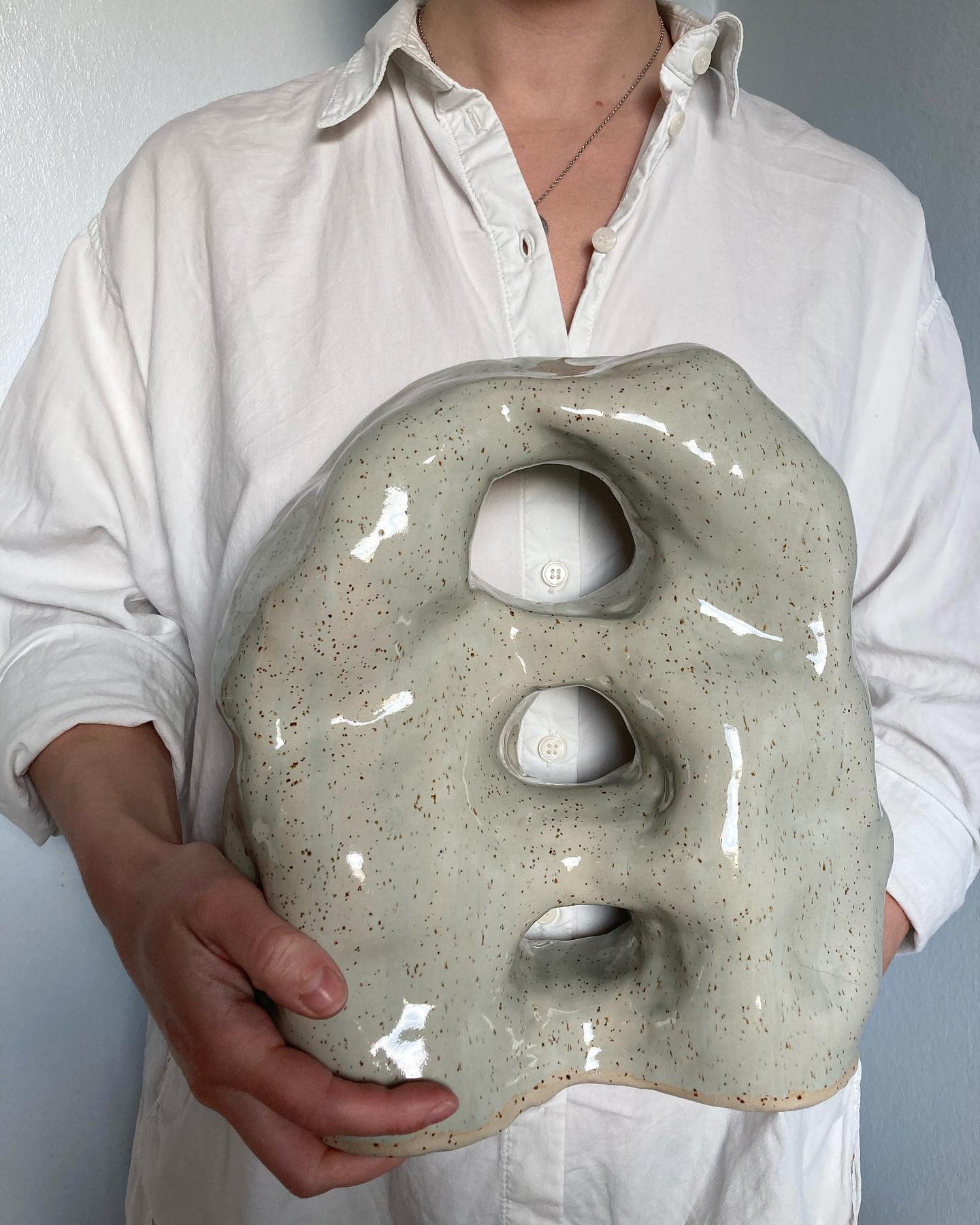 Grön skulptur med hål i stengods